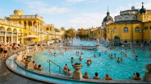 Steaming turquoise outdoor thermal mineral pools of Szechenyi Baths in Budapest surrounded by yellow Neo-Baroque colonnades (AI Generated Image)
